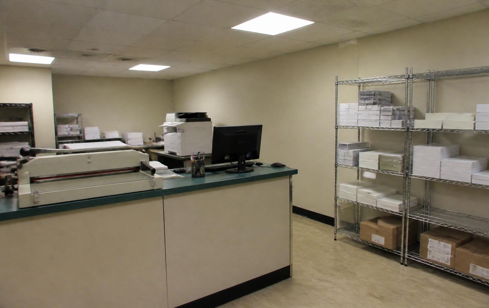 Press and stacks of paper on the shop floor at Derby Printing Company in Louisville