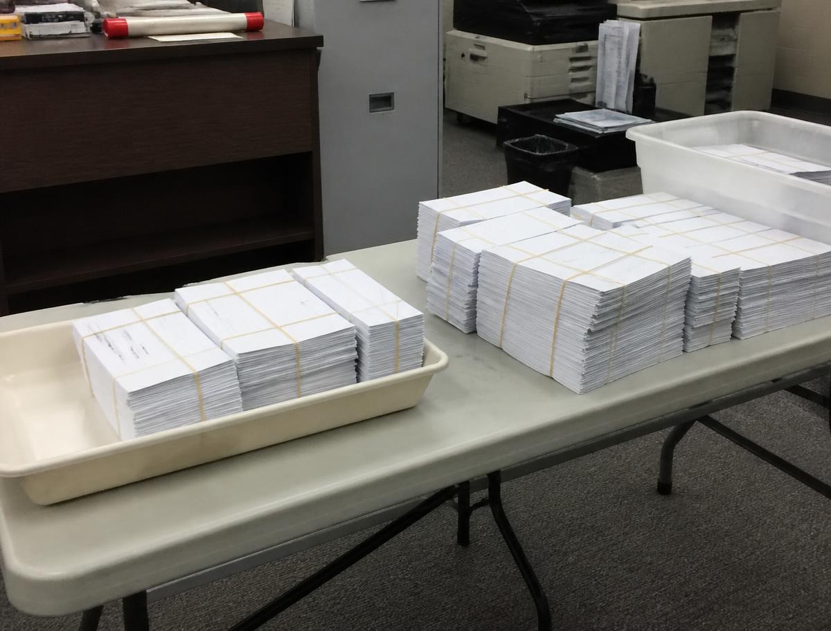 Banded bundles of addressed envelopes in postal trays ready to mail