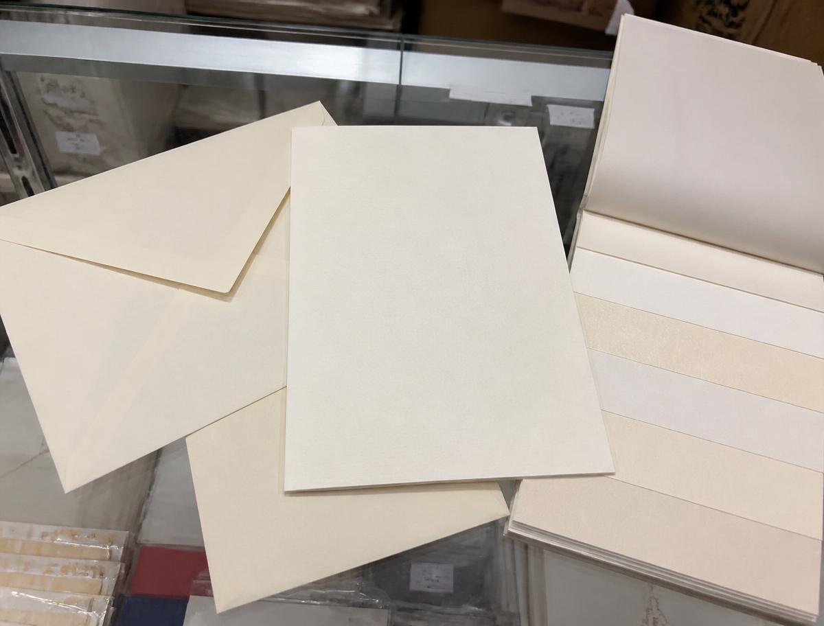 Wedding invitation card stock, matching envelopes and paper samples on the counter